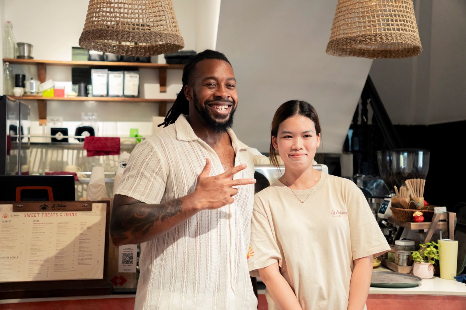 A guest and a barista smiling at the coffee counter