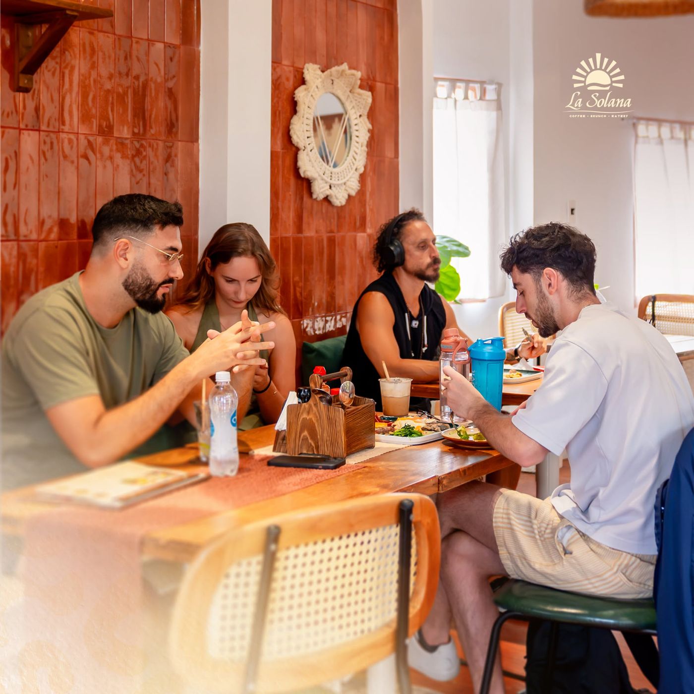 A group of friends sharing brunch by the terracotta arches