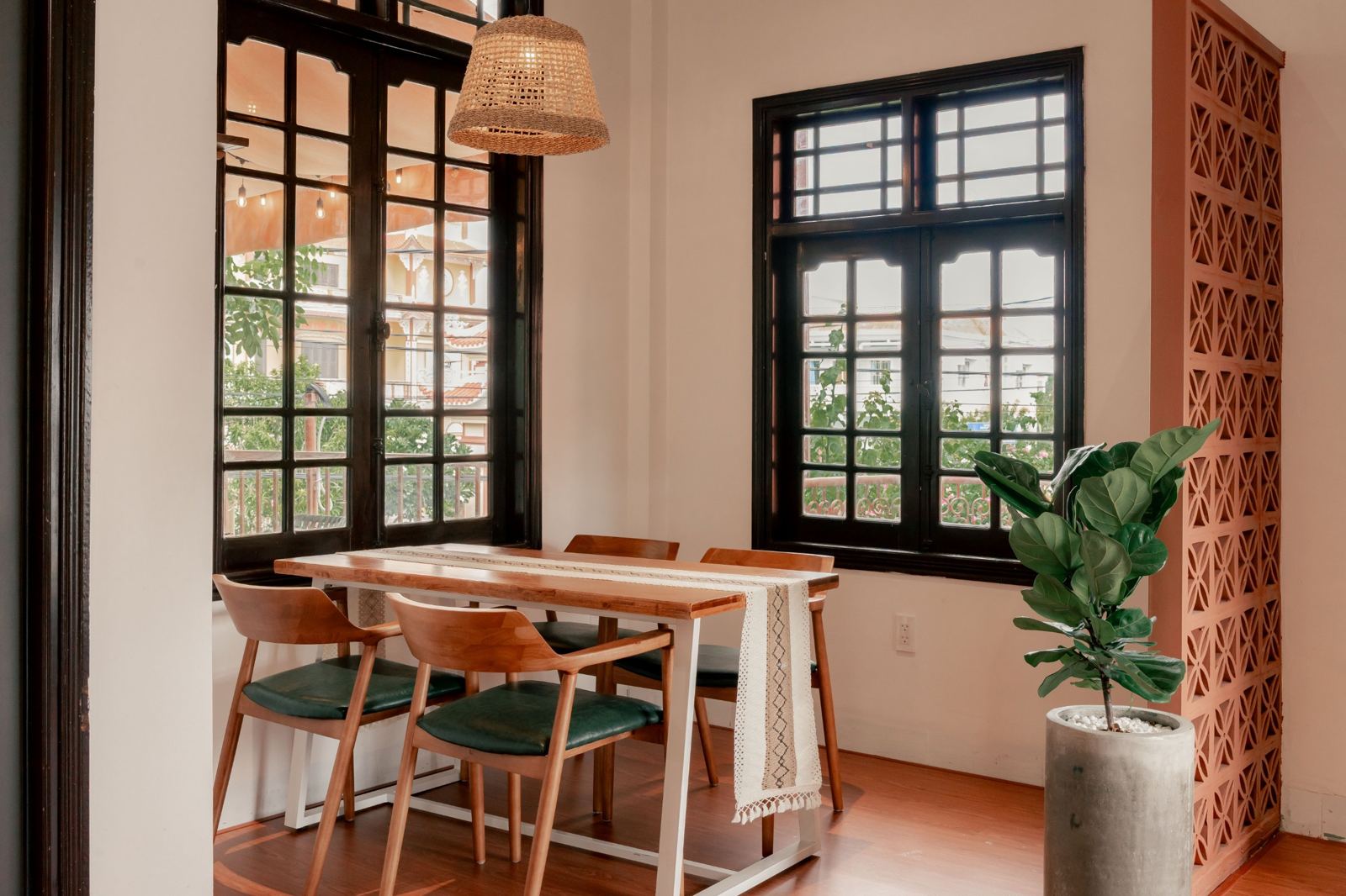 A table by tall dark-framed windows looking onto the terrace